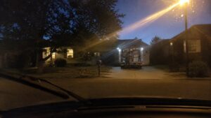 Emergency restoration response vehicle at residential property with technicians unloading equipment at twilight