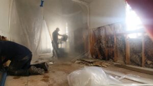 Restoration technician using FLIR thermal imaging camera to assess water damage in Utah residential home